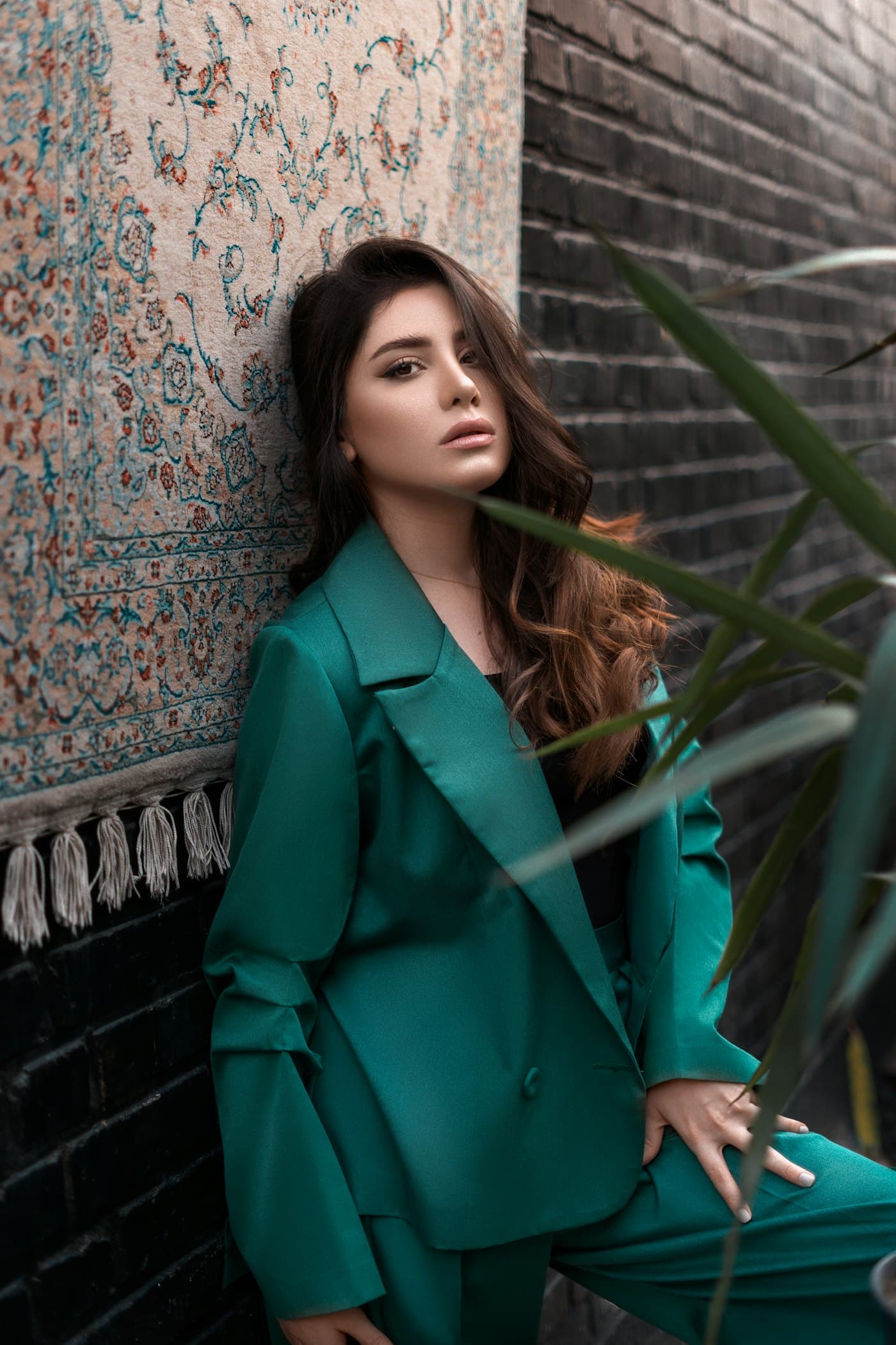 Founder portrait in a tailored blazer beside a plant