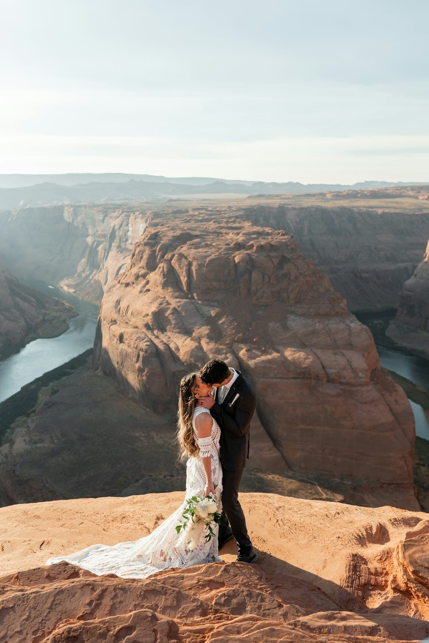 Couple embracing at a canyon overlook during golden hour