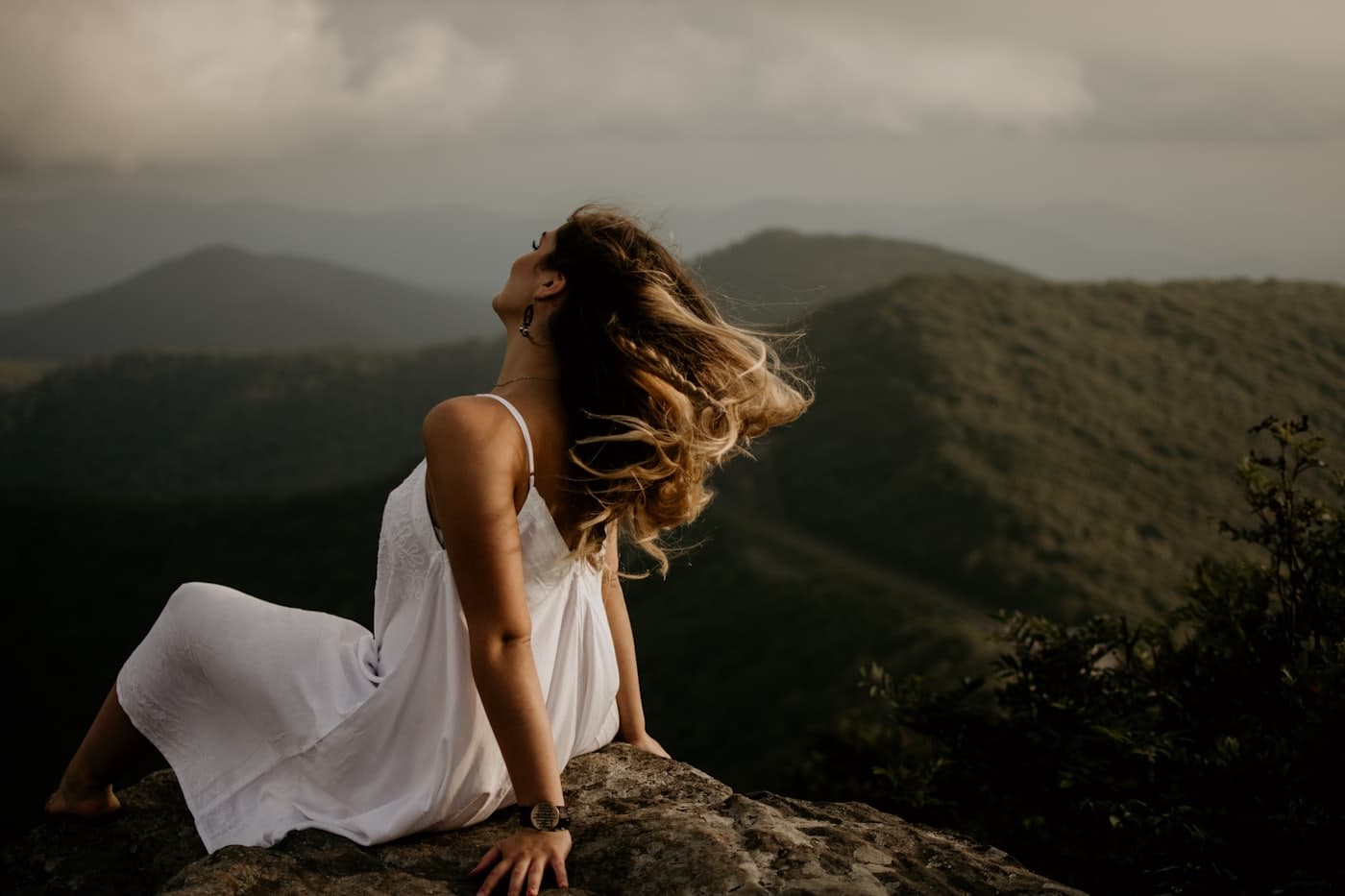 Bride seated on a high desert hillside