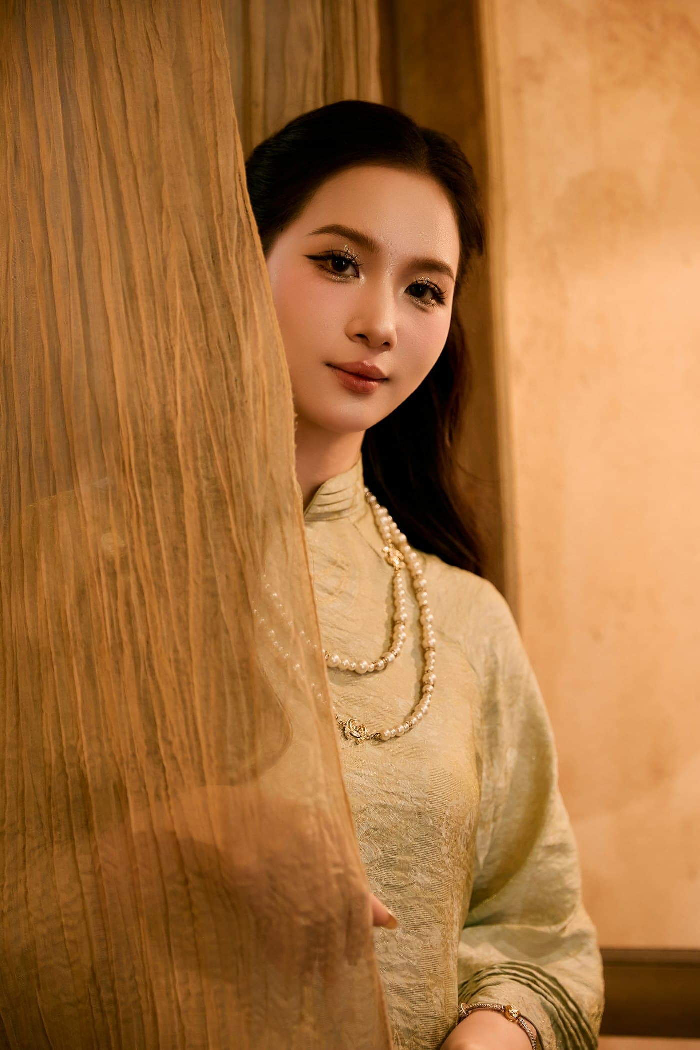 Portrait of a woman glancing from behind a curtain